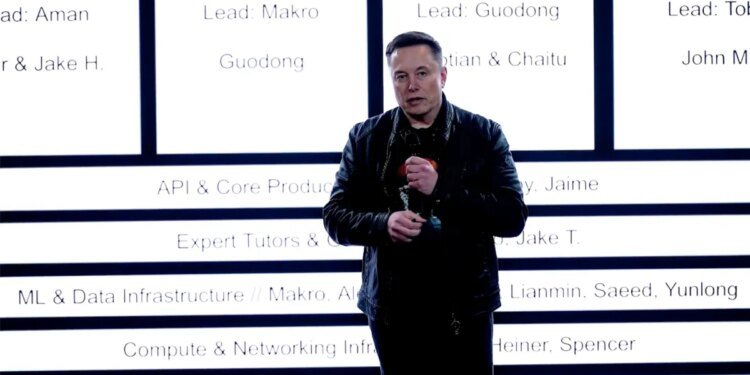 Elon Musk stands in front of xAI's new org chart