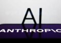 AI sign displayed on a screen and Anthropic logo displayed on a phone screen are seen in this illustration photo.