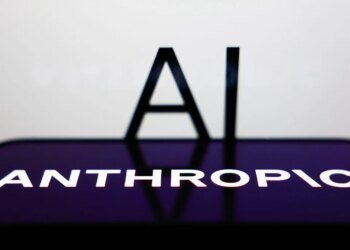 AI sign displayed on a screen and Anthropic logo displayed on a phone screen are seen in this illustration photo.