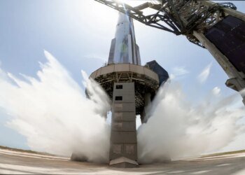 A view of SpaceX's starship system on the launchpad with the water-cooling flame deflector system active