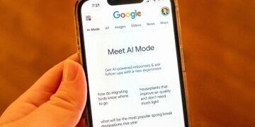 A person holding an iPhone and using Google AI Mode