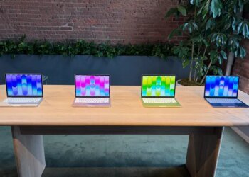 four macbook neo laptops in different colors on a table