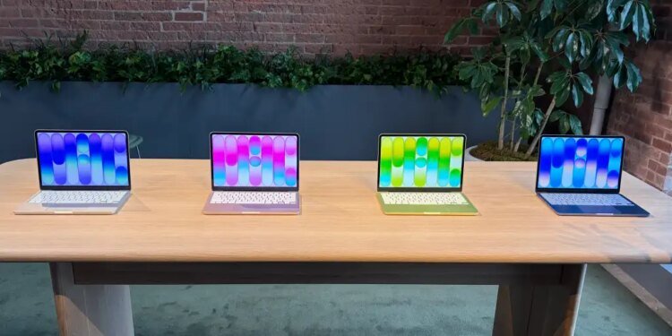 four macbook neo laptops in different colors on a table