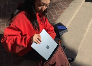 young woman putting Apple MacBook Air into a satchel