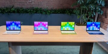 four macbook neo laptops in different colors on a table